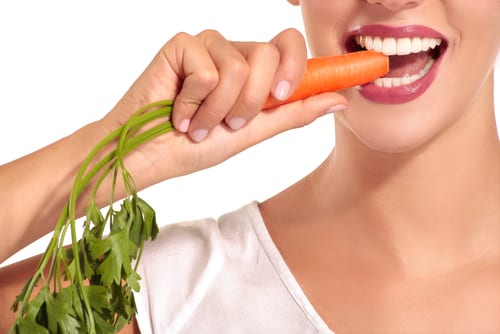 Woman biting a carrot