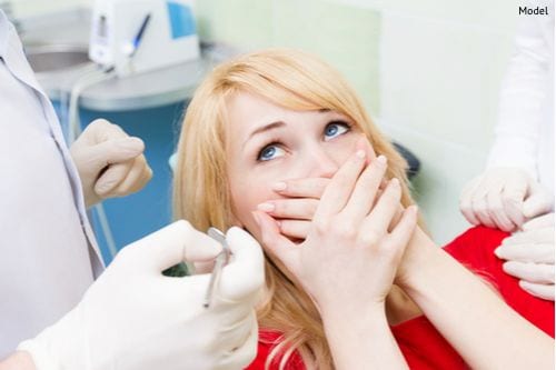 Closeup portrait young terrified girl woman scared at dentist visit