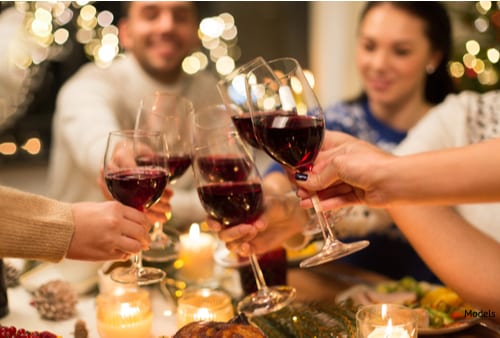 Many alcoholic drinks enjoyed during the holiday season, like the group pictured above drinking red wine, are high in sugars that can eventually lead to tooth decay and damage.