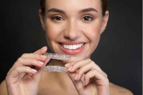 Woman excited about wearing her ClearCorrect™ aligner trays to give her a beautiful smile.