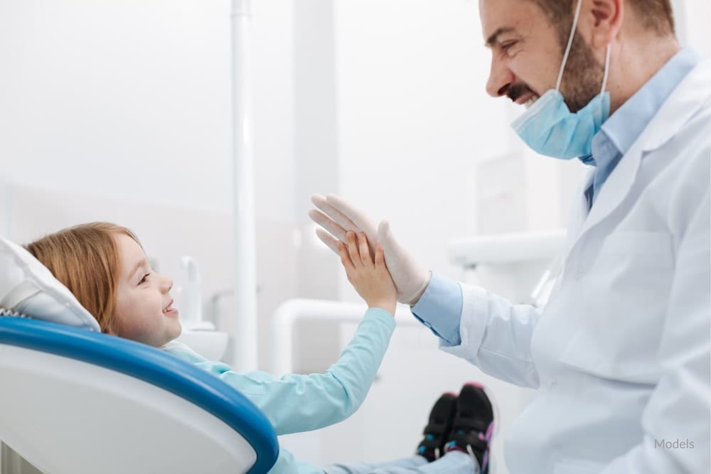 Dentist giving his young patient a high-five