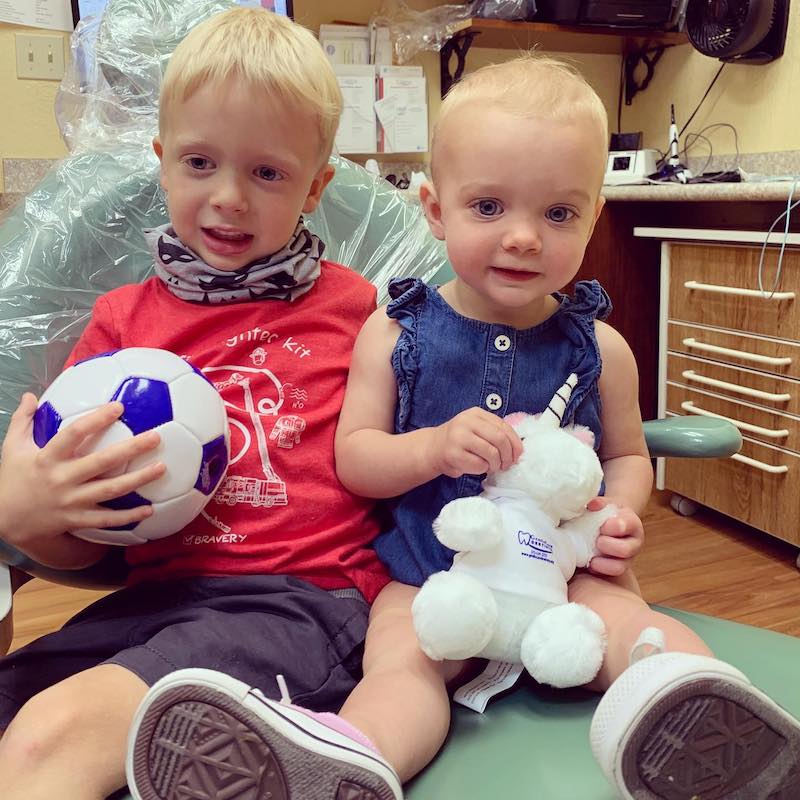 Two children sitting in a dentist office.