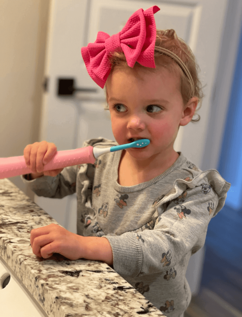 Toddler girl brushing teeth.