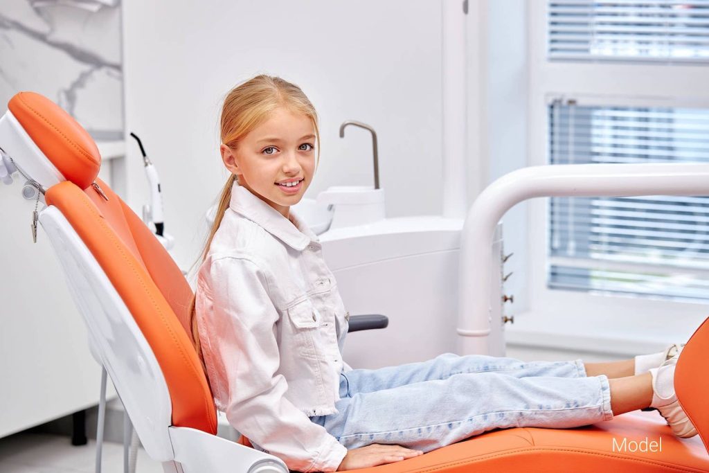 Little girl sits in a dentist's chair.