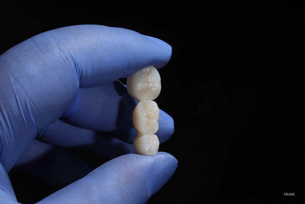 Hand holding a dental bridge