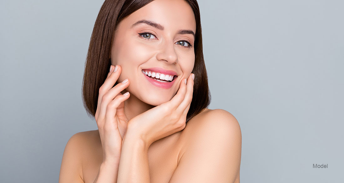 Woman smiling touching her face