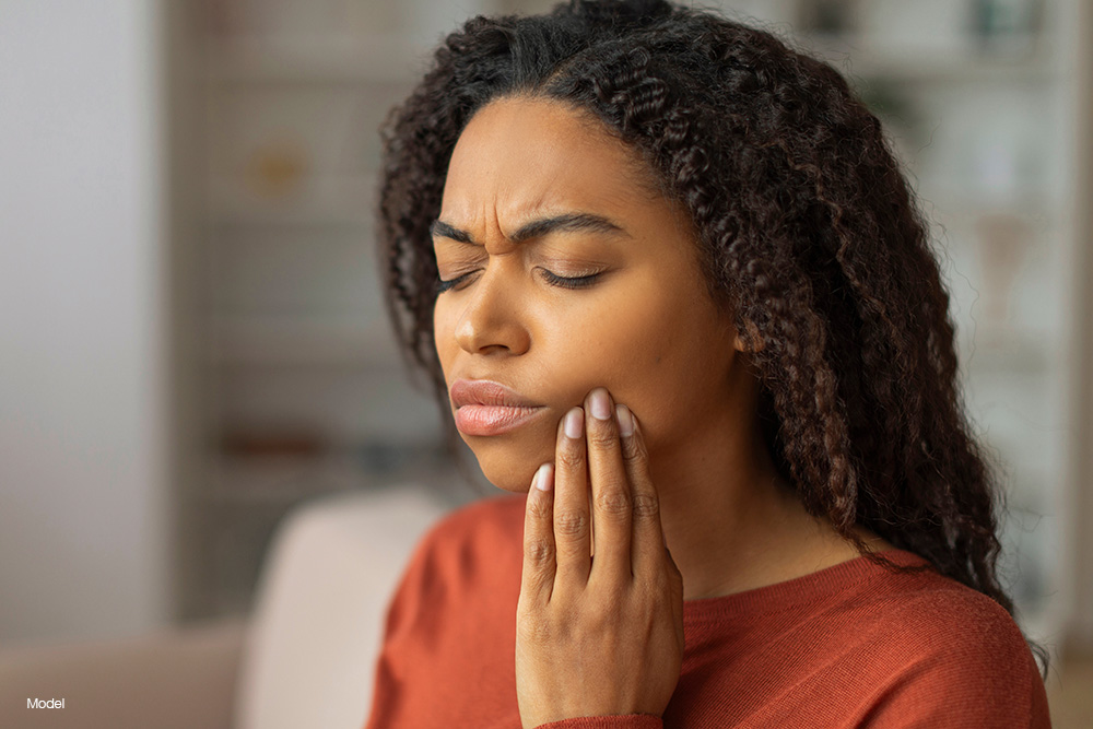 Woman holding her mouth in pain