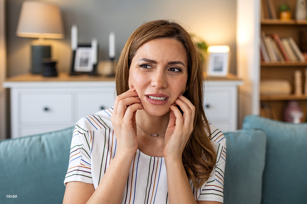 Woman holding her mouth in pain